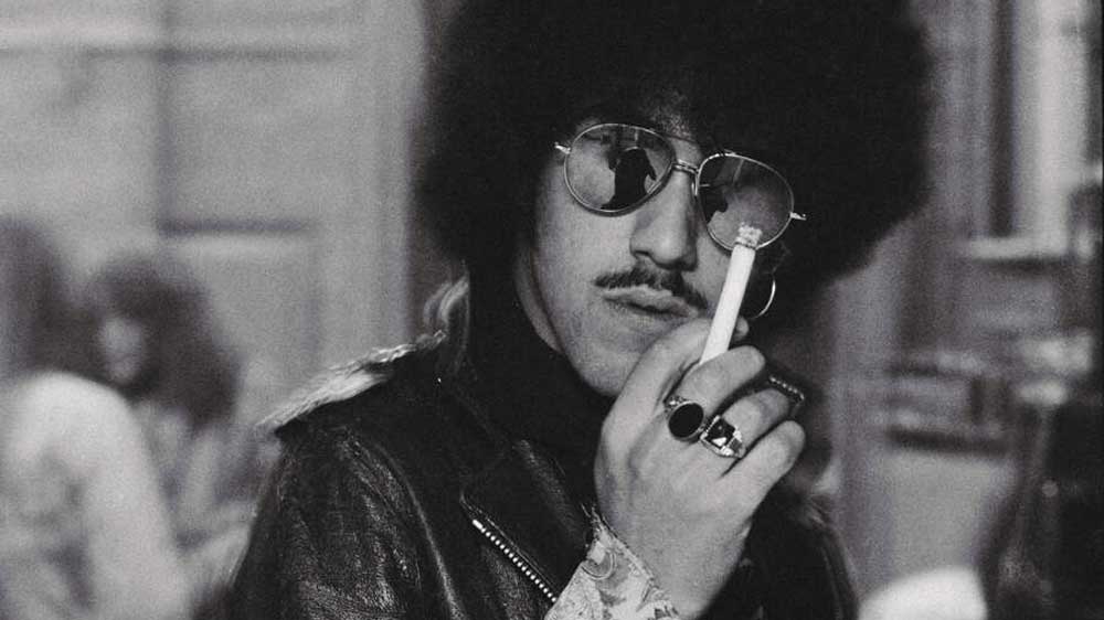 Phil Lynott in sunglasses, smoking a cigarette (1975)