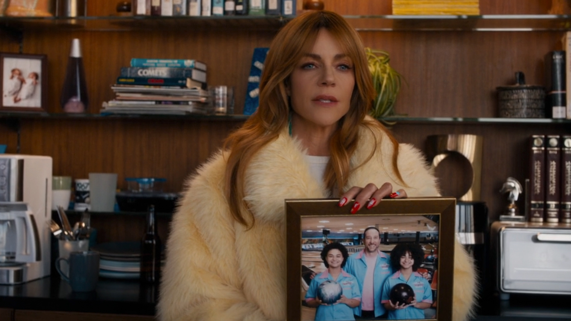 Kaitlin Olson holding up a photo on High Potential