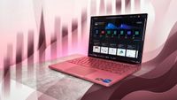 A pink laptop on a gray surface, displaying a dark-themed screen with apps. The background has abstract pink and maroon wave patterns, creating a modern, dynamic feel.