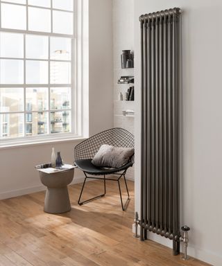 large radiator in living space with window and armchair