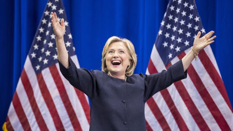 Hillary Clinton gestures with her arms as she addresses a crowd.