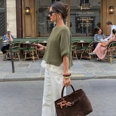 @leasy_inparis wears a green jumper with ecru jeans and brown accessories