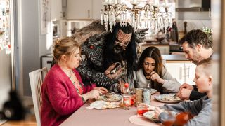 Mr Lordi at a table with a family eating food