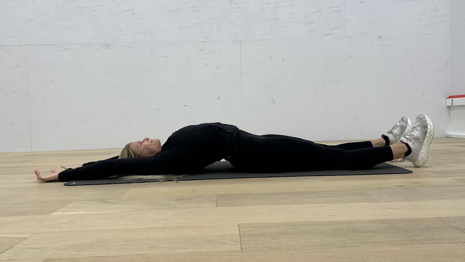 Woman demonstrates stretches in a fitness studio