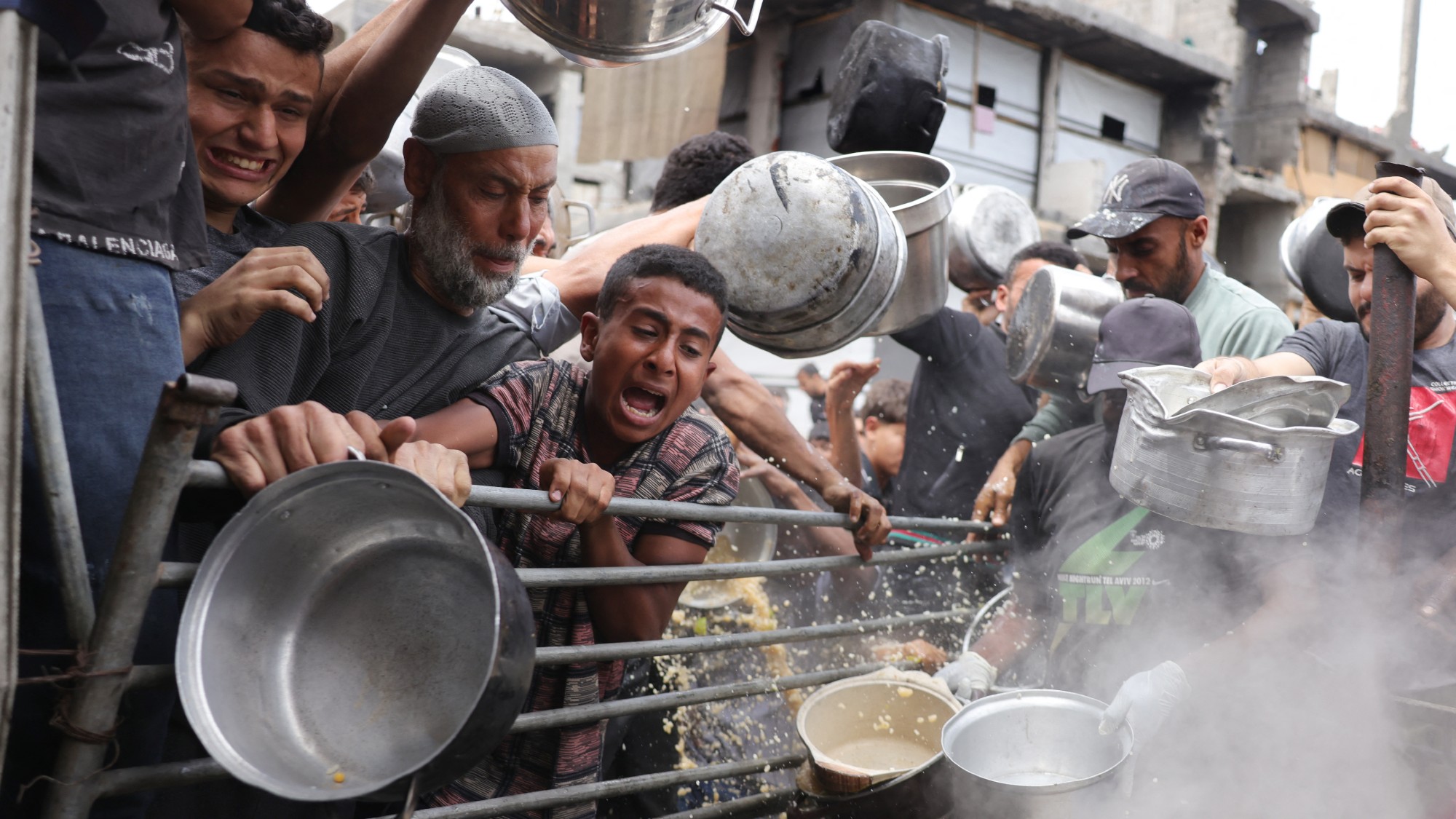 Palestinians try to access food rations outside a crowded distribution centre in Beit Lahia, northern Gaza, on 15 May
