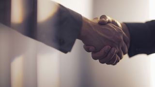 A close up of a handshake denoting a corporate deal