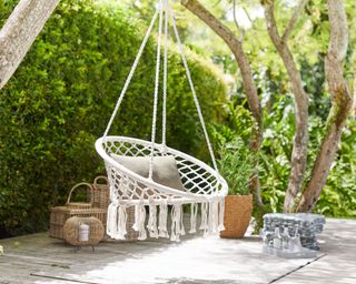 hanging chair on wooden deck with rattan accessories