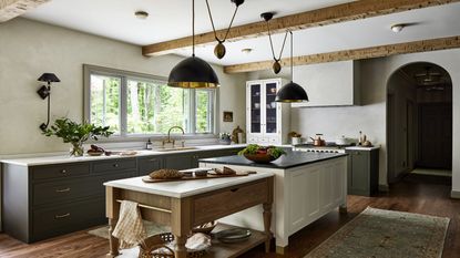 Two kitchen islands in farmhouse style kitchen with grey cabinets and grey pendant lighting