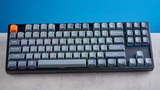 Keychron K8 Max mechanical keyboard in gray photographed on a blue background