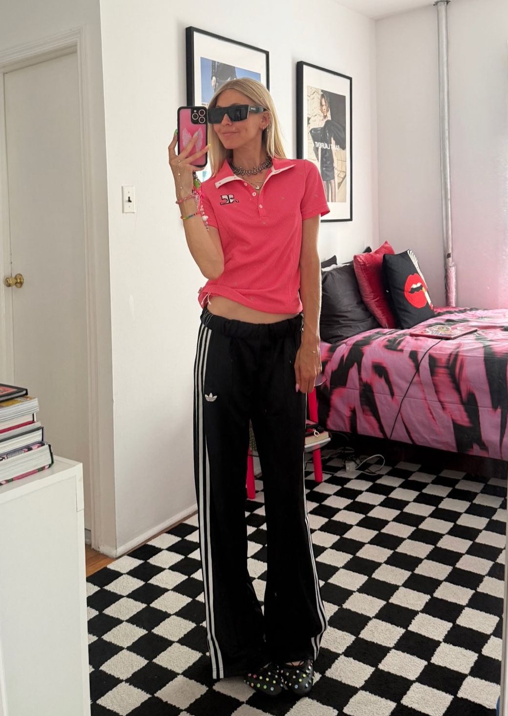 Jessica Minkoff posing in mirror wearing pink top and black pants 