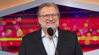 Drew Carey holding microphone hosting The Price Is Right
