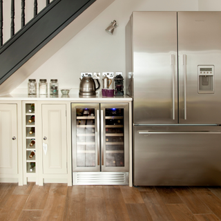 Clever under stairs storage for a large stainless steel double fridge, wine fridge and tea station.