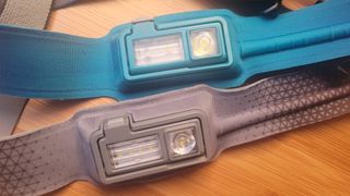 Side by side comparison of the power buttons. The top is the new HeadLamp 425 and the grey band is the older HeadLamp 330