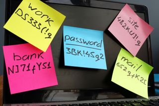 Passwords written on colored Post-It notes and stuck to a laptop screen.