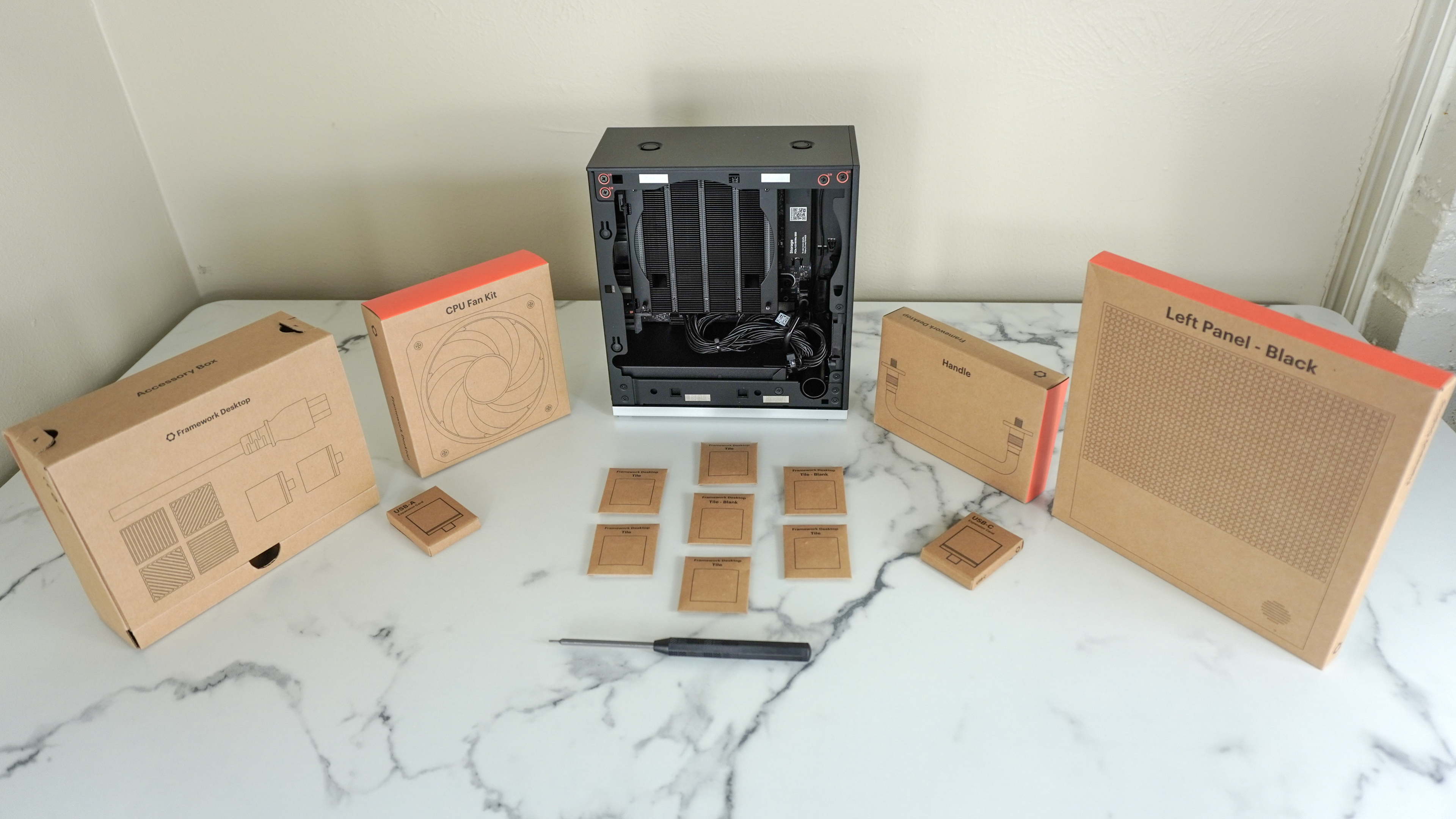 The Framework Desktop on a desk with all of its various pieces in boxes around it