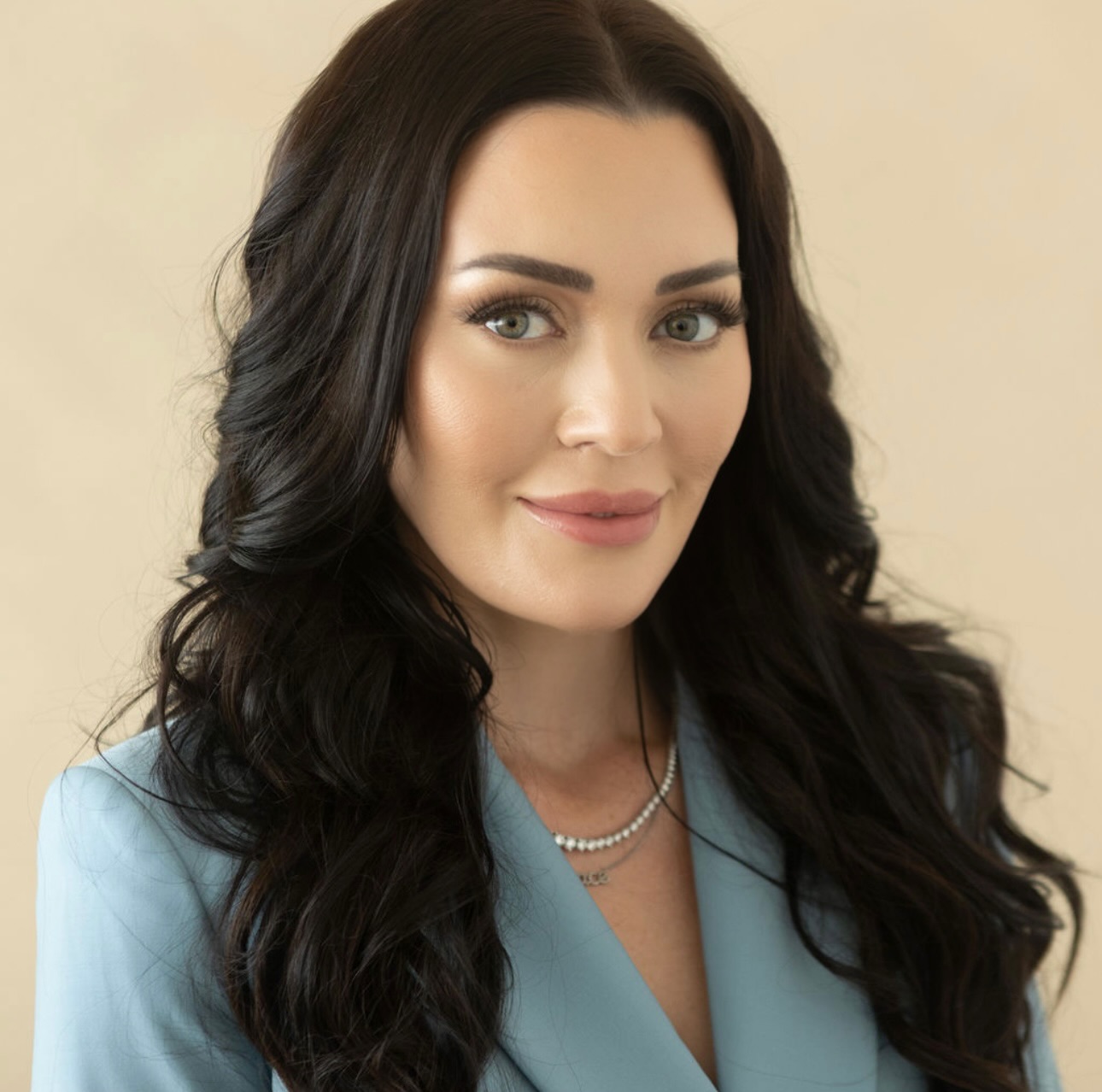 a white woman with brunette hair in a light blue jacket