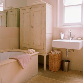 white bathroom with cupboard and bathtub