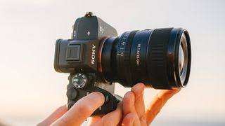Best lenses for Sony A7iv - hands holding Sony A7 IV with FE 35mm f/1.4 GM lens