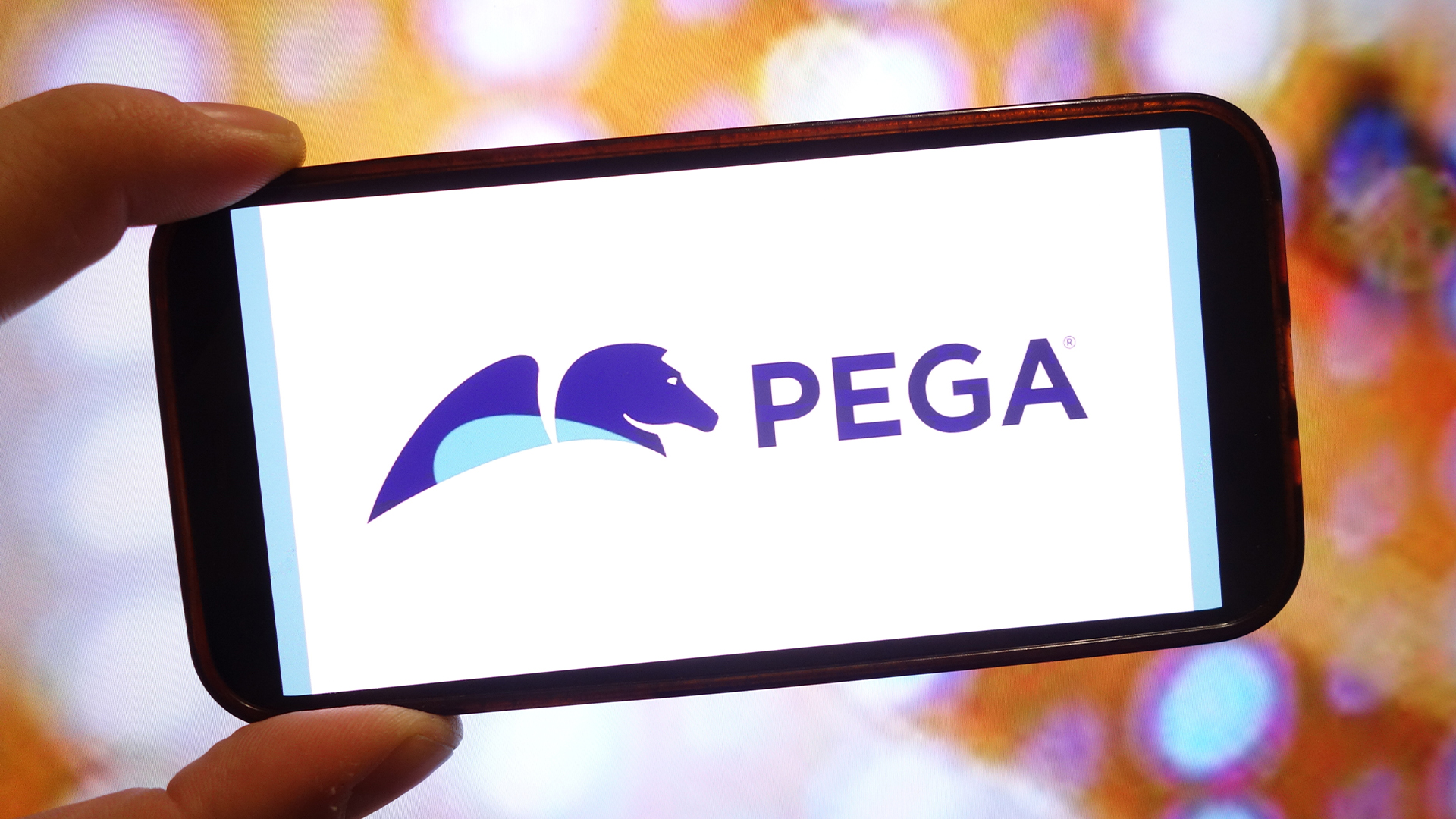 Pegasystems (Pega) logo and branding pictured on a smartphone screen held in person's hand.