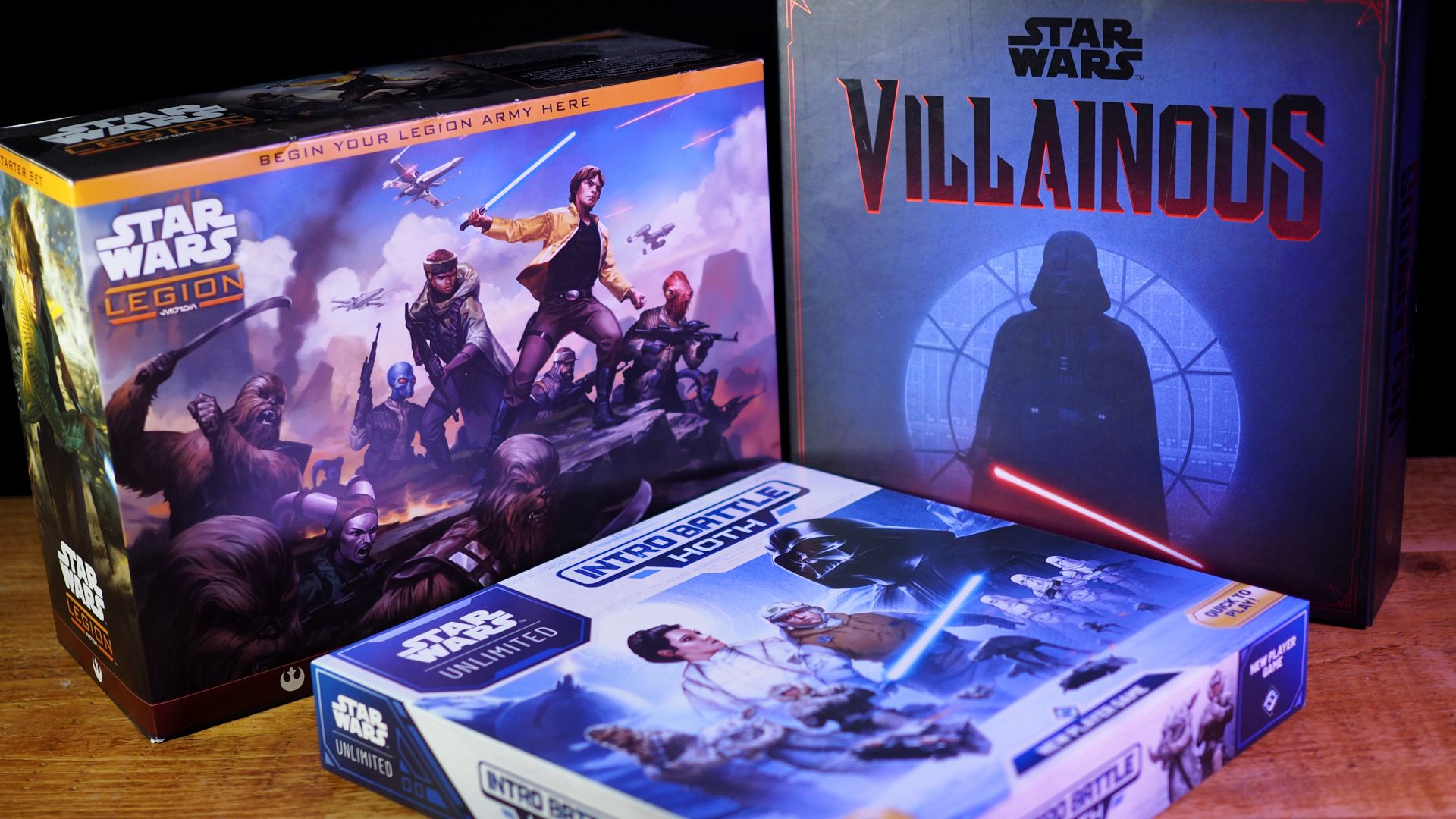 Star Wars Legion, Star Wars Villainous, and Star Wars Unlimited: Intro Battle Hoth laid out on a wooden surface