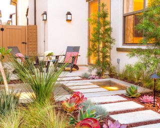 A contemporary side yard with stepping stones and a water feature