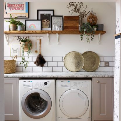 White tiled and marble utility room with fitted washer and dryer