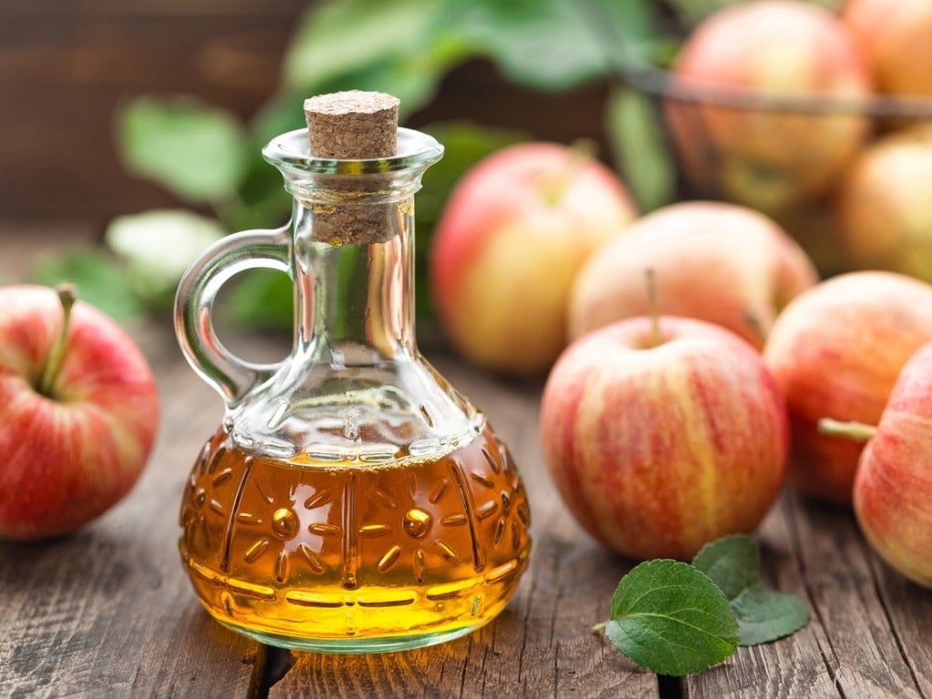 Glass Jar Of Flavored Vinegar Next To Apples