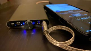 iFi hip-dac 3 next to a smartphone on a black table