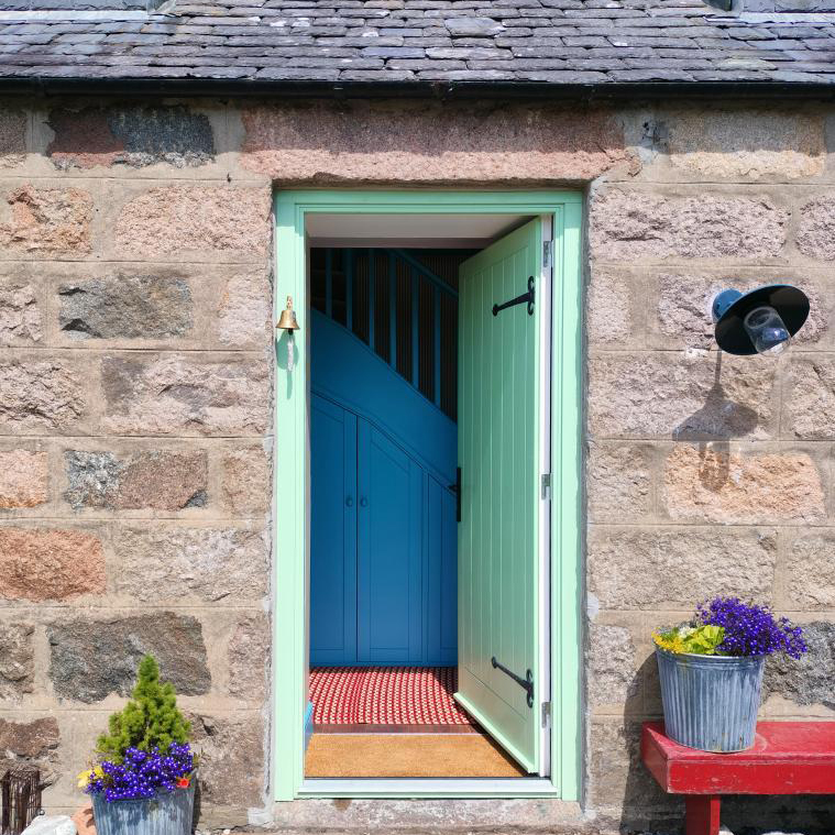 green door looking into a blue staircase