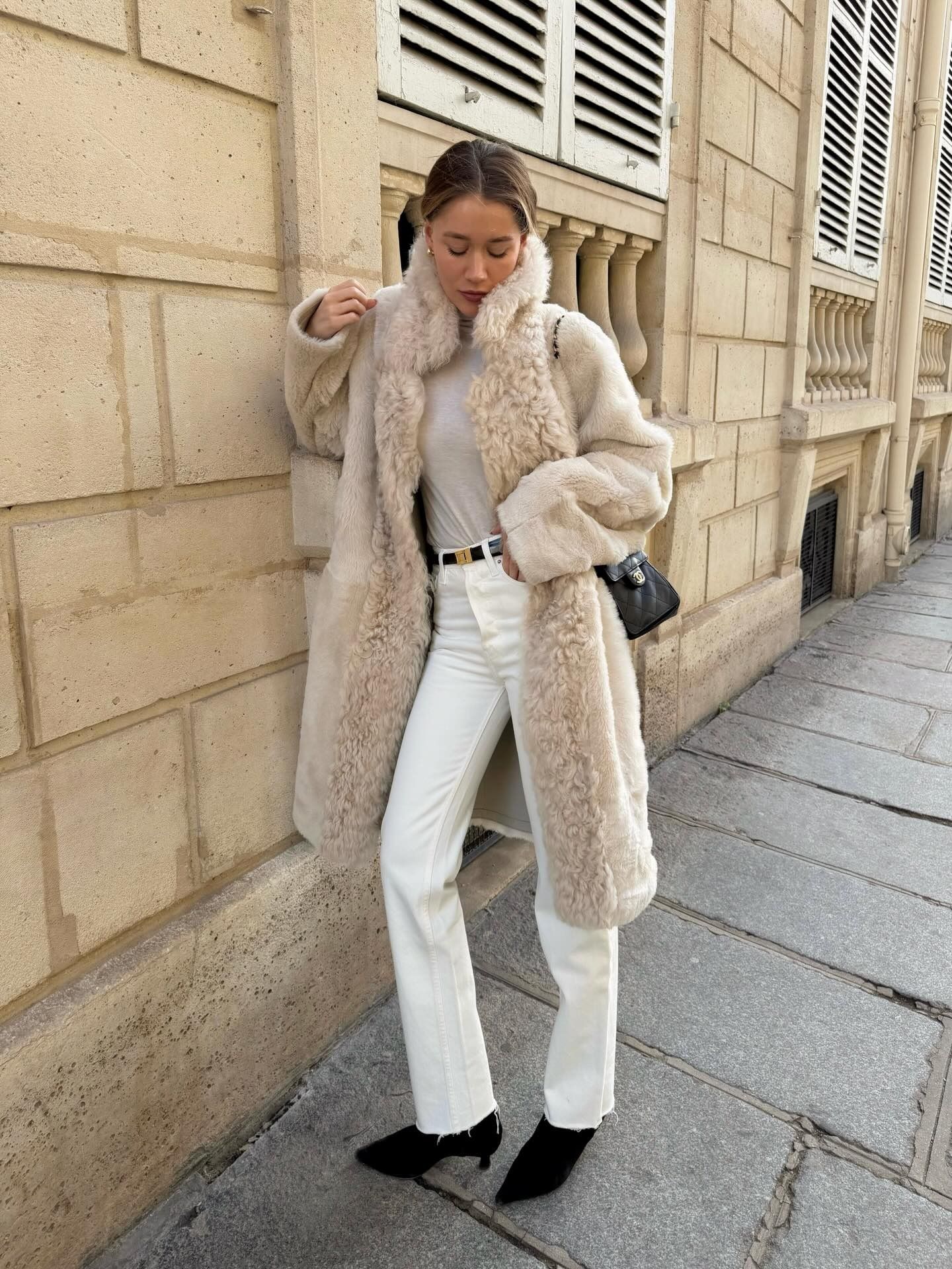 Woman in white cigarette jeans and a cozy coat