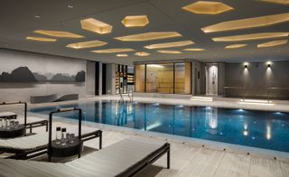 Indoor swimming pool, loungers and side tables