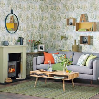 Cosy living room with wall-to-wall tree green wallpaper and a grey sofa