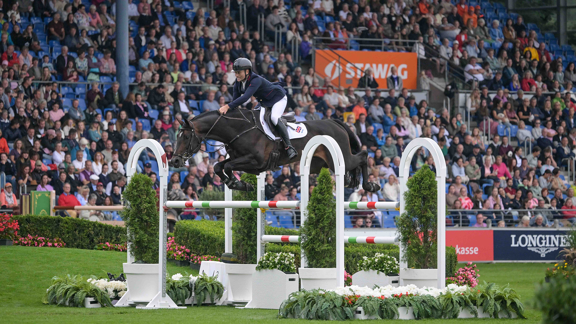 British rider Adrian Whiteway and Chacco Volo clear a large oxer during the speed leg of the showjumping World Championships in Aachen, Germany
