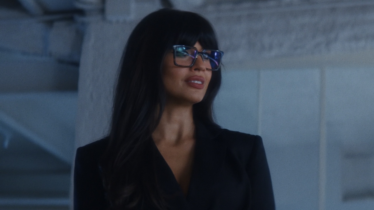 Jameela Jamil wearing glasses in black pantsuit in People We Meet On Vacation
