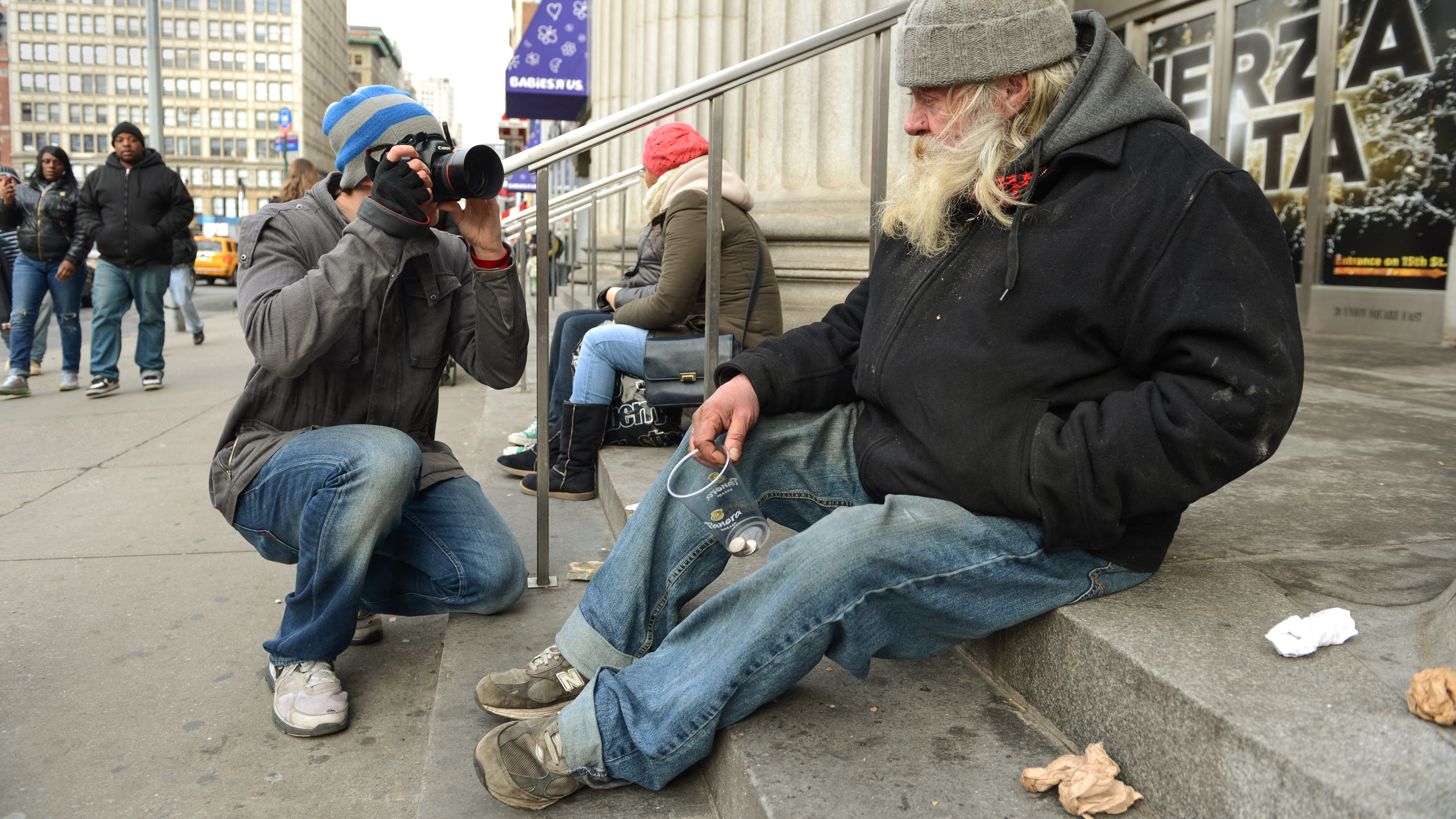 Brandon Stanton (L), creator of the Humans of New York blog, photographs a man named Carl (R) February 22, 2013 across the street from Union Square in New York. Some like New York's skyscrapers, bridges, his energy, taxis or lights. But Brandon Stanton has set himself another challenge: photograph of 10,000 inhabitants for a blog now famous &amp;quot;Humans of New York.&amp;quot; In two years, he has photographed 5,000 New Yorkers, children leaving school, tramps, fashionistas, New York with a bouquet of tulips, old lady with a cane, municipal employees, etc. And nearly 560,000 fans now follow his Facebook page.AFP PHOTO/Stan HONDA (Photo by STAN HONDA / AFP) (Photo by STAN HONDA/AFP via Getty Images)