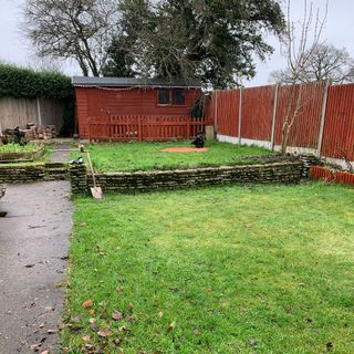 Back garden with lawn, path and wooden fence