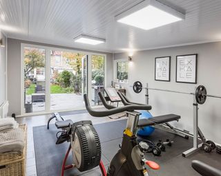 A garden room home gym with LED panel lighting