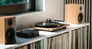 Pro-Ject Stereo Box E flanked by a turntable and speakers