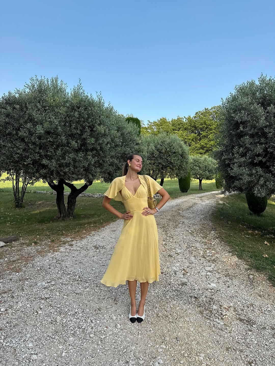 woman wearing yellow midi dress with fairy sleeves summer 2025