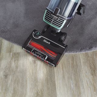 Shark vacuum on rug and hard floor from above.