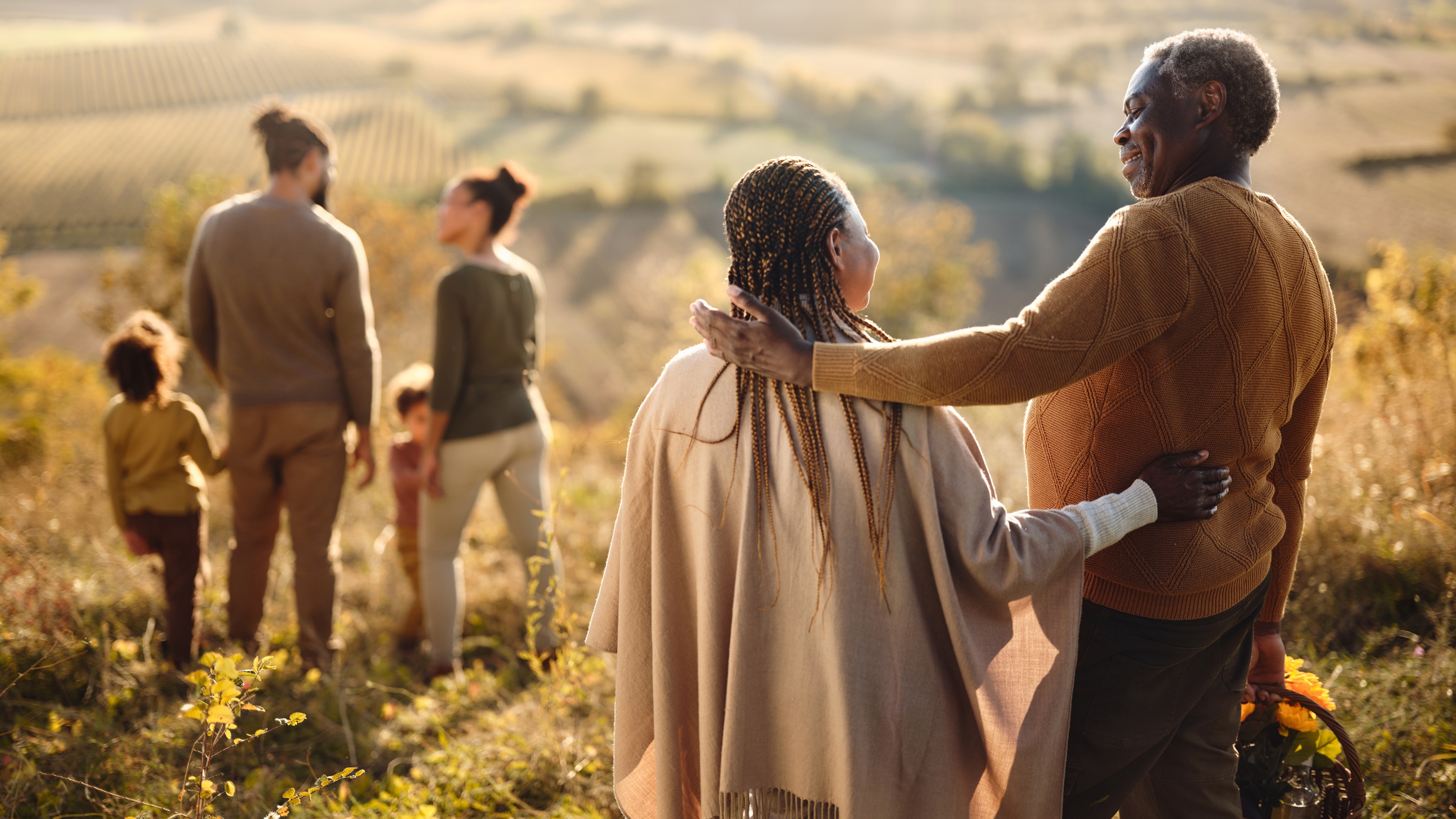 A multigenerational family on a hike through a field.