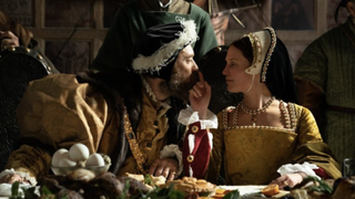 A still from the movie Firebrand showing Alicia Vikander as Katherine Parr and Jude Law as Henry VIII sat at a banquet table