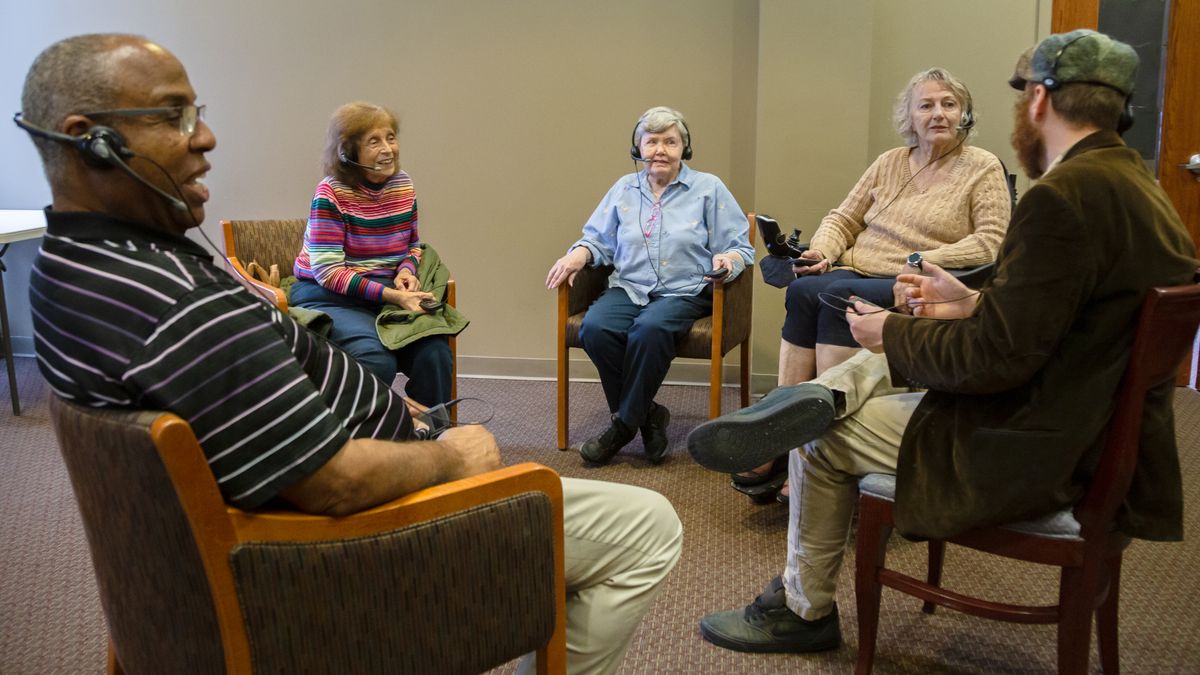 Residents at an assisted living center use ListenTALK technology for hearing assistance.