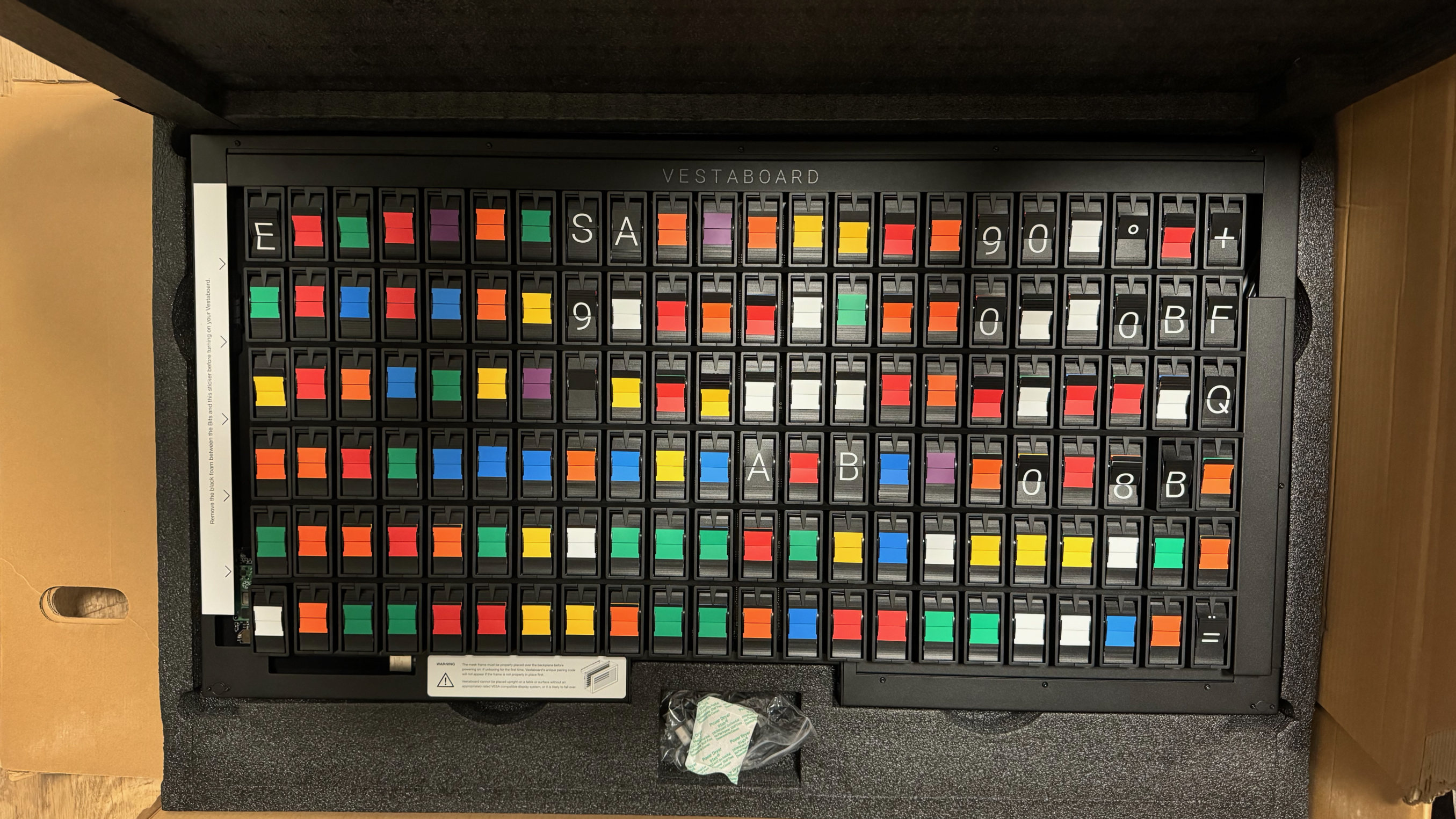 The Vestaboard in the box without front case