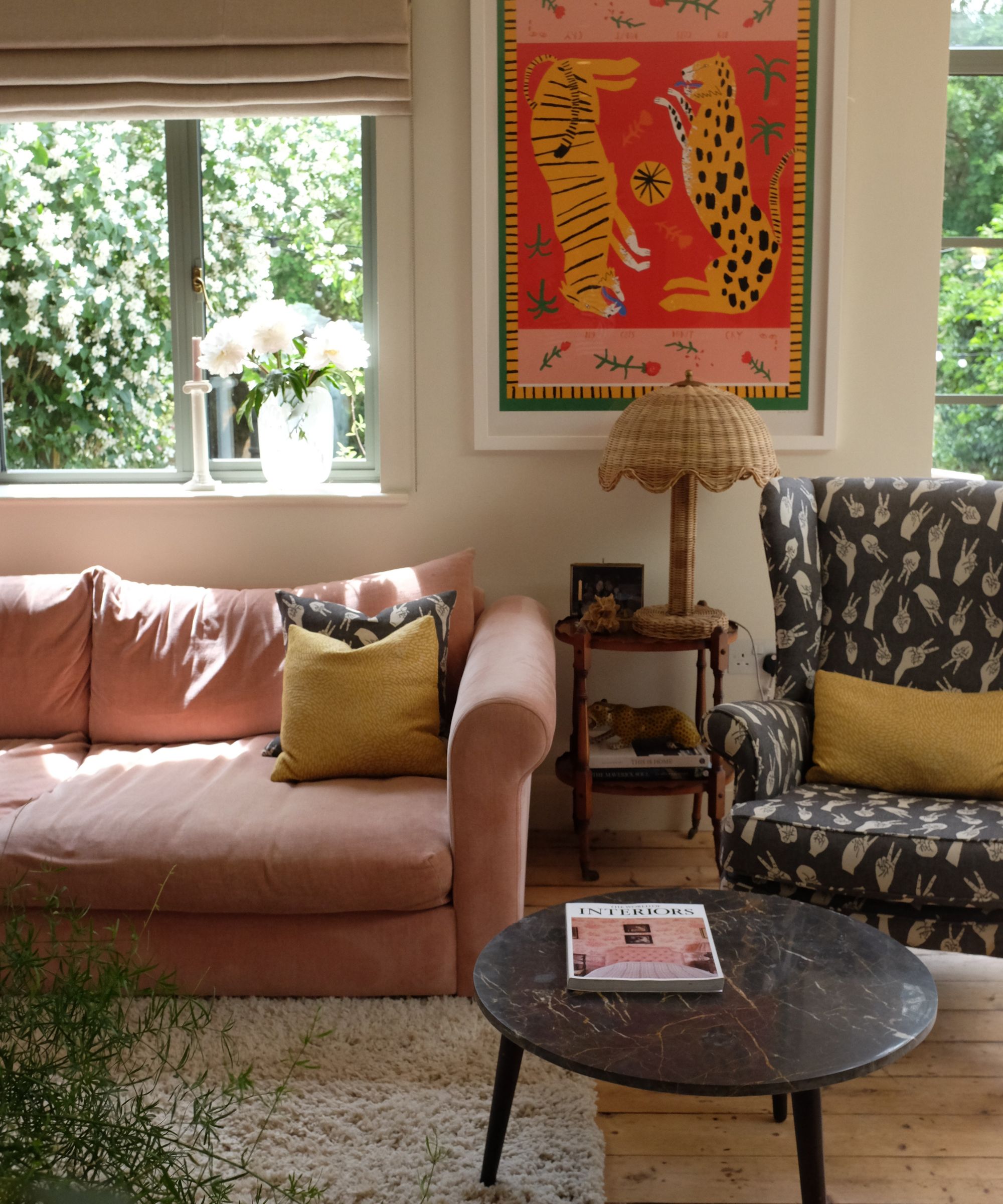 Beige living room with pale pink sofa, black marble coffee table and pink and red artwork