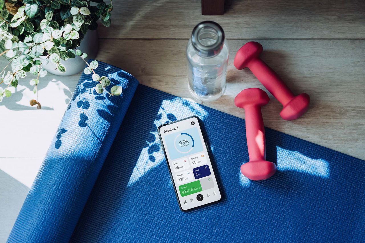 a pair of the best dumbbells next to a phone for a full home workout