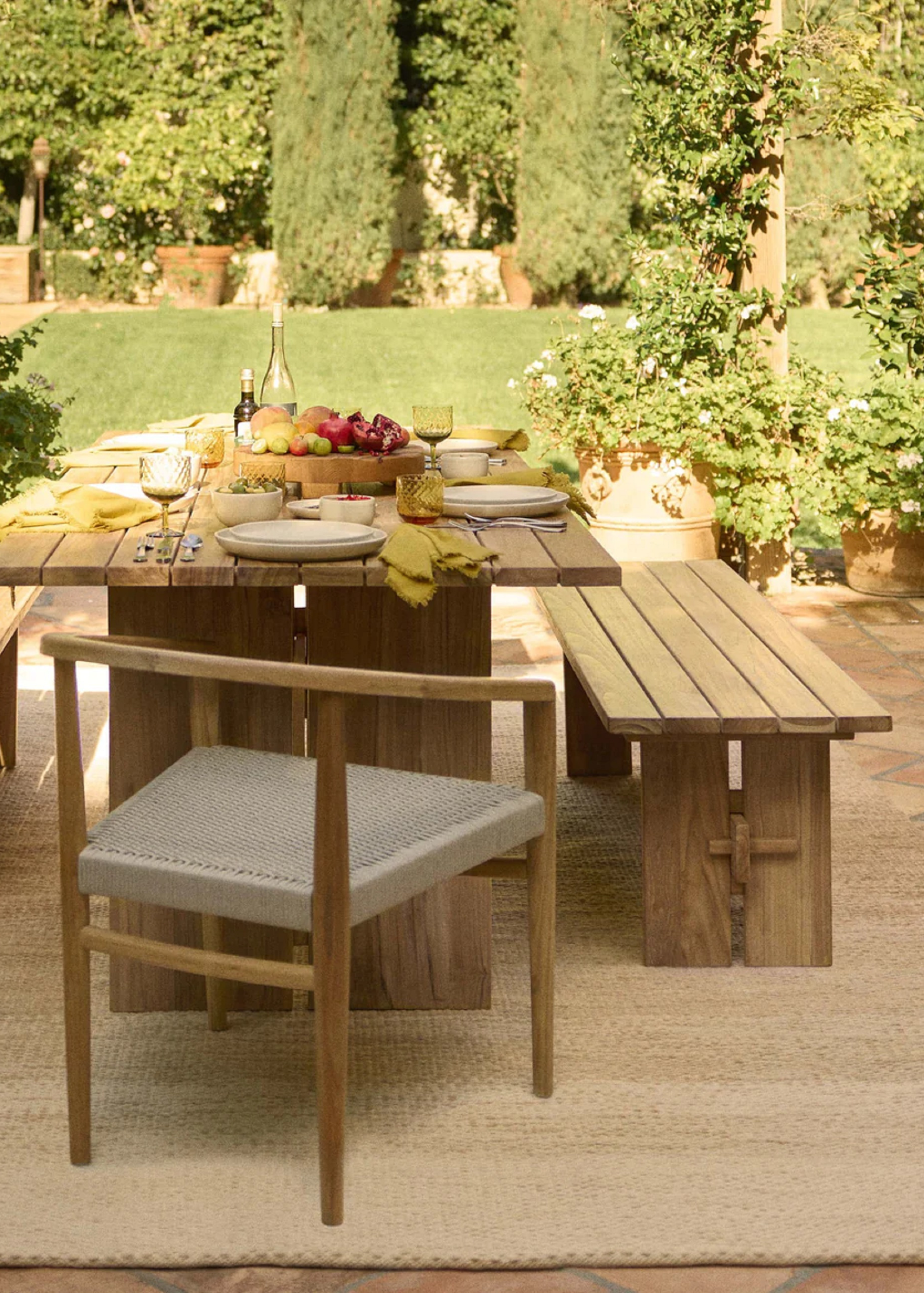 lulu and georgia outdoor dining table set with greenery and garden area in the background