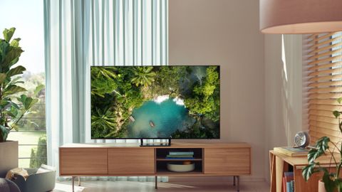 The Samsung AU9000 TV on a wooden cabinet in a living room.