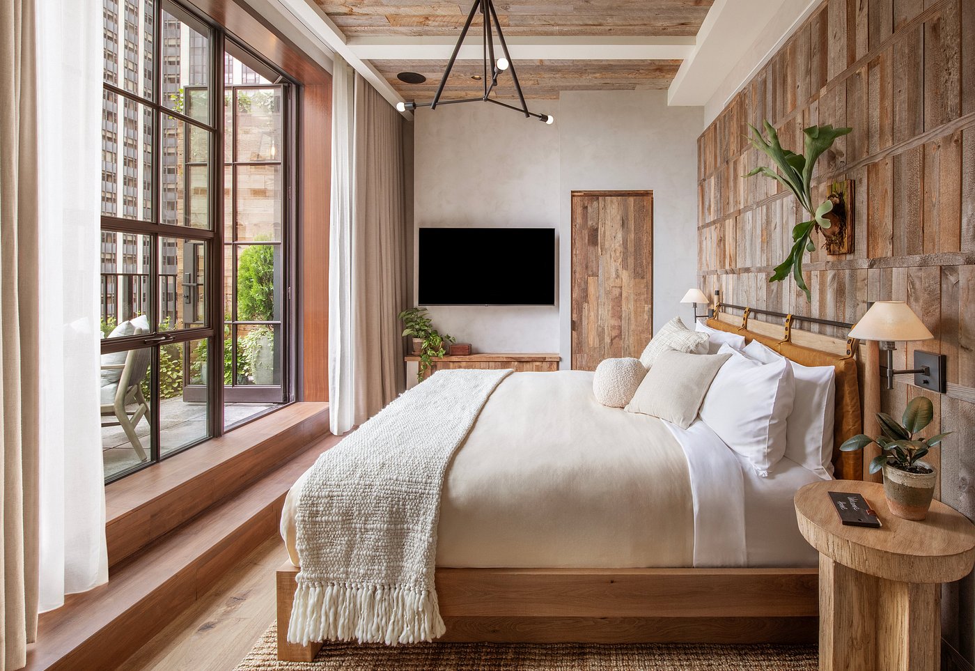 A nature-inspired hotel features wood-clad walls and trailing plants along with soft, wool furniture and cocooning interiors.