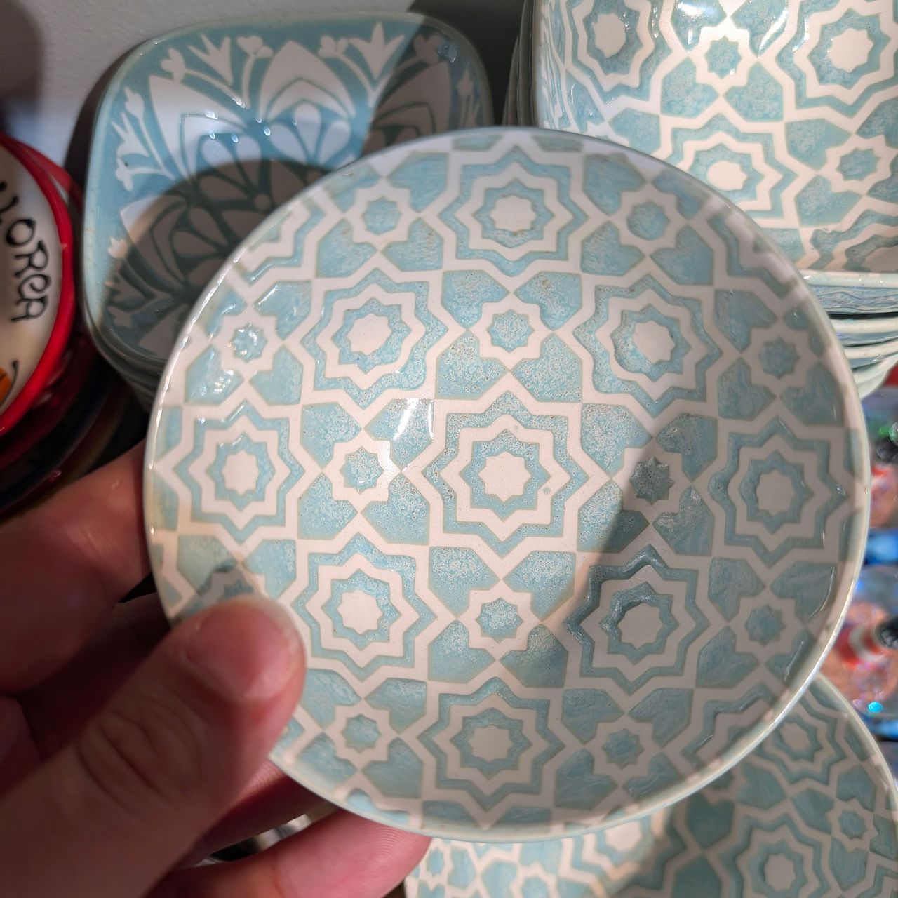Person holding small blue and white patterned bowl